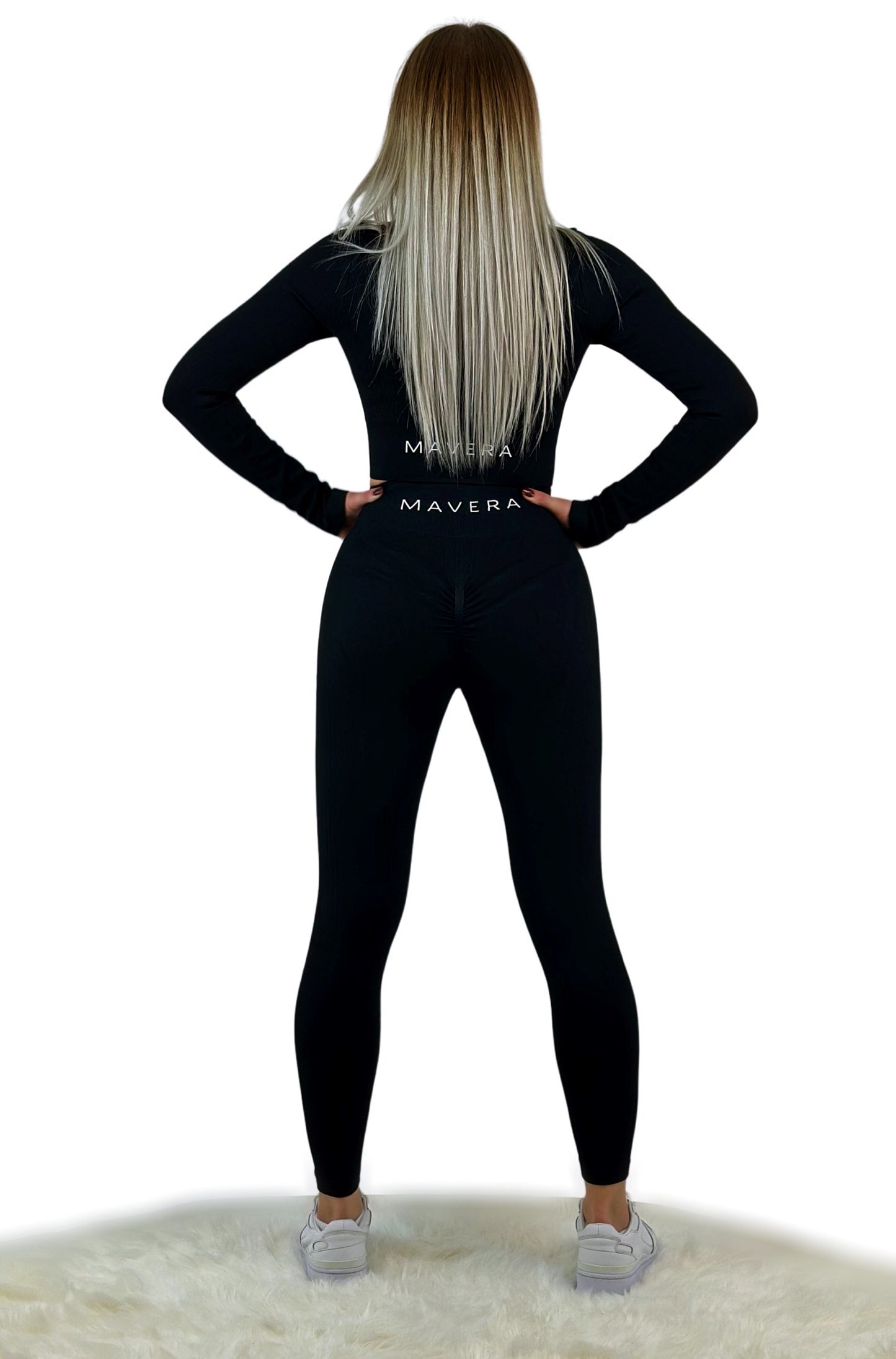 Schwarzes Sport Set für Frauen mit Reißverschluss am langärmligen Oberteil und anschmiegsamer High Waist Leggings. Activewear aus der Tribute Kollektion, bestehend aus hochwertigem Spandex/Nylon mit gerippter Oberfläche. Die Kollektion bietet einen eleganten Look für sportliche Aktivitäten und den Alltag, ist atmungsaktiv, nahtlos, reversibel und feuchtigkeitsabweisend. Verfügbar in drei stylischen Farboptionen